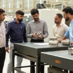 A precision-machined component is being inspected at the Shilpan Steelcast Precision Machining Facility in India.